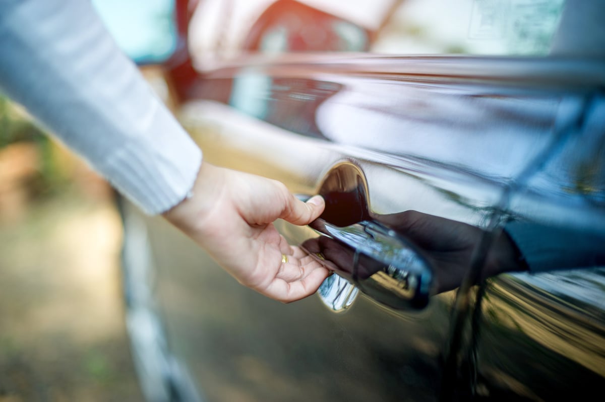 Hand opening a car door at the start of a transfer