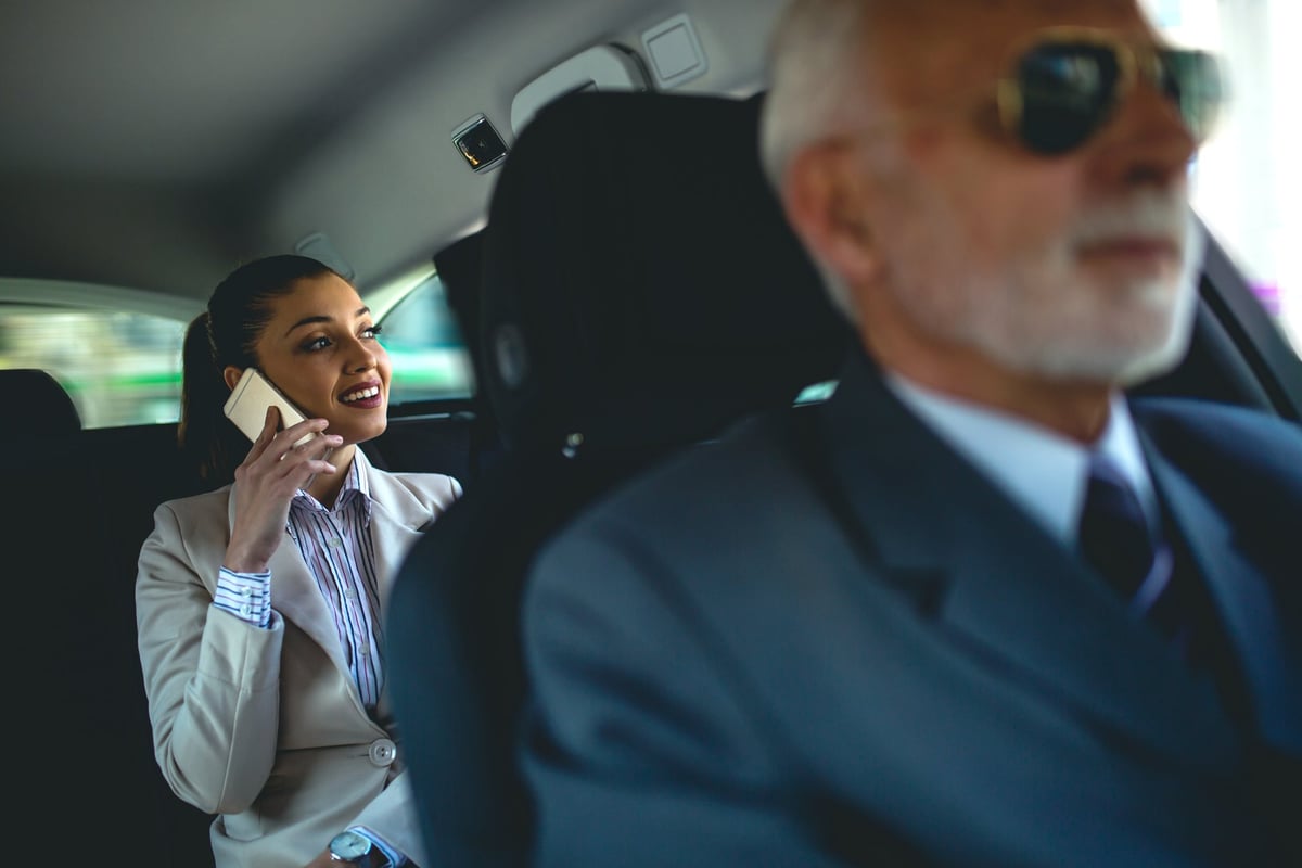 Passenger working in the back of a private car