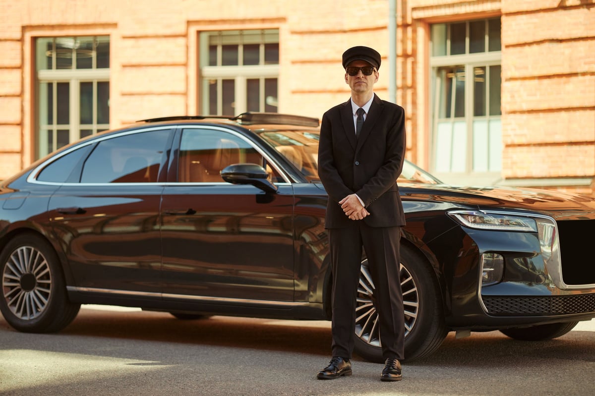 Chauffeur beside a premium vehicle